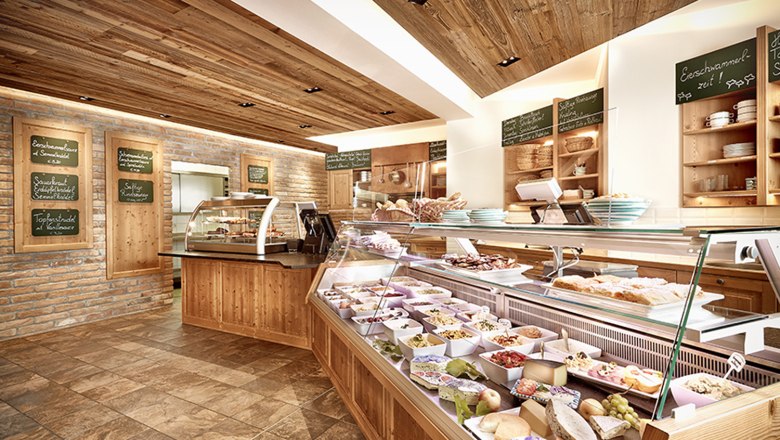 Heurigenlokal, © Weingut Wannemacher Innenansicht eines Heurigenlokals mit Theke und Speisen.