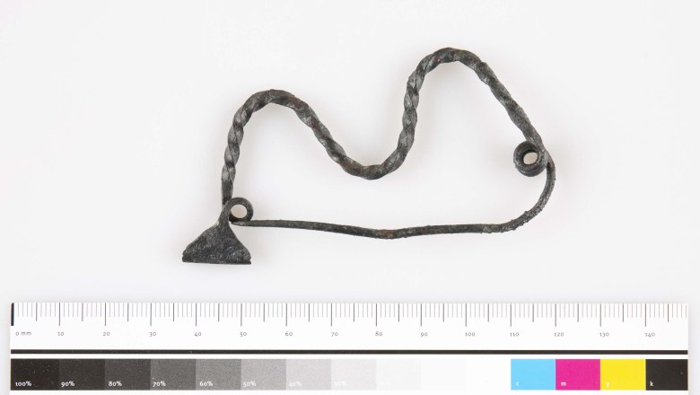 Metallobjekt mit verdrehtem Draht und Ma&szlig;stab.