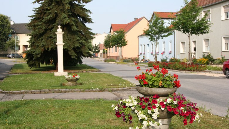 Stra&szlig;e in Sierndorf mit bunten Blumen und H&auml;usern.